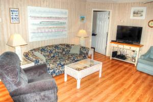 sala de estar con sofá y TV en Guest Cottage 30G, en Myrtle Beach