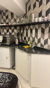 a kitchen with a black and white checkered wall at Valentino in Termas de Río Hondo +12 photos