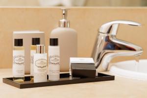 a bathroom counter with three bottles of soap and a sink at Vale Do Lobo Resort in Vale do Lobo
