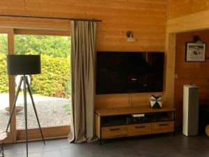 ein Wohnzimmer mit einem Flachbild-TV an einer Holzwand in der Unterkunft Beautiful 5-bed chalet in Les Carroz d'Araches in Les Carroz d'Araches