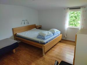 ein Schlafzimmer mit einem Bett mit blauen Kissen darauf in der Unterkunft Kvarngården i Torp in Byxelkrok