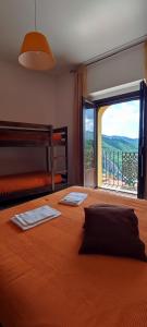 a bedroom with a large bed with a large window at Al Cuore del Borgo in Castelmezzano