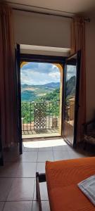Zimmer mit einer Tür zu einem Balkon mit Aussicht in der Unterkunft Al Cuore del Borgo in Castelmezzano