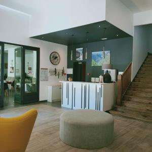 - un salon avec une table, un tabouret et des escaliers dans l'établissement Hotel du Levant, à Castellane