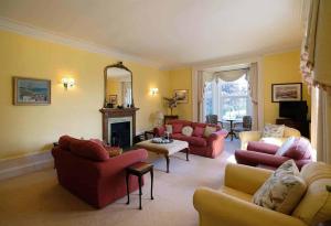 sala de estar con muebles de color rojo y chimenea en Mains of Orton, en Fochabers