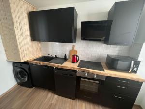 cocina con fregadero y microondas en Casa Faro - Joli T2 - Hyper Centre Brive Rue Commerçante, en Brive-la-Gaillarde