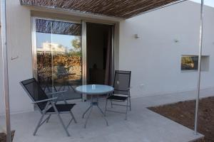 eine Terrasse mit einem Glastisch und 2 Stühlen in der Unterkunft giardino del tempo in Merine