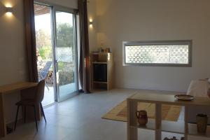 a living room with a table and a door to a kitchen at giardino del tempo in Merine