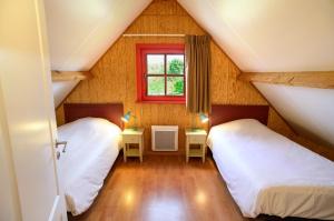 a attic room with two beds and a window at Domaine Du Val in Grand-Laviers +42 photos