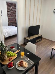 una sala de estar con una mesa con comida. en Casa Faro - Joli T2 - Hyper Centre Brive Rue Commerçante, en Brive-la-Gaillarde