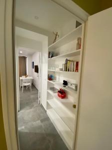 Cette chambre dispose d'un couloir avec des étagères blanches. dans l'établissement Chez les artistes de Ménilmontant, à Paris