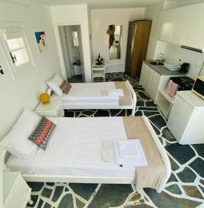 2 camas en una habitación pequeña con cocina en Sing and Blossom Accommodation, en Mykonos ciudad