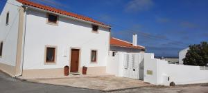 a white building with a gate and a white fence at Casa Vitorino's in Vale de Maceira