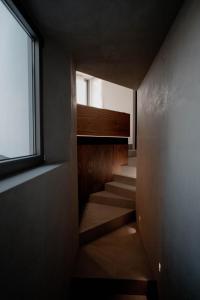- un escalier dans une maison avec une fenêtre dans l'établissement PNOĒS Tinos, à Tinos