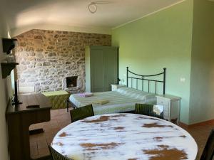 a bedroom with a bed and a table with chairs at Mini Appartamenti Nonna Nella in Barbarasco