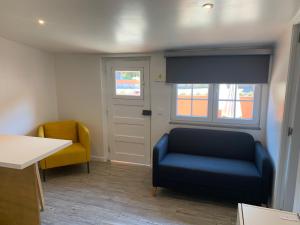 a waiting room with a blue couch and a yellow chair at Quinta da Bicuda in Cascais