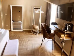 Zimmer mit einem Schreibtisch, einem Bett und einem Spiegel in der Unterkunft Gatto Bianco Rooms 42 in Bergamo