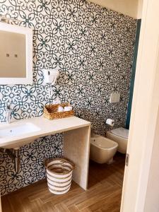 ein Bad mit einem Waschbecken und einem WC in der Unterkunft Gatto Bianco Rooms 42 in Bergamo