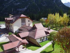 eine Luftansicht eines Hauses mit rotem Dach in der Unterkunft Villaggio Turistico Ploner in Schluderbach