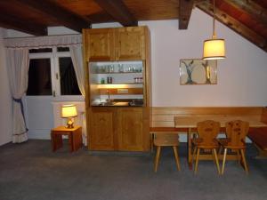 Villaggio Turistico Ploner في كاربونين: غرفة طعام مع طاولة وكراسي خشبية