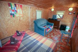 a living room with a blue chair and a desk at Karavan Sturovo in Štúrovo