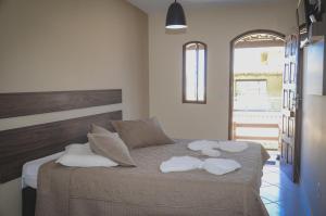 a bedroom with a bed with towels on it at Pousada Beach House in Cabo Frio