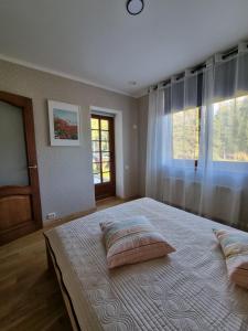 1 dormitorio con cama con almohadas y ventana en Vāgnera parks en Tukums