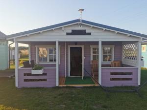 a pink house with a roof and a porch at Fioletowy in Niechorze