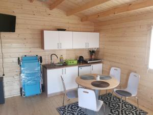 a kitchen with a table and chairs in a cabin at Fioletowy in Niechorze