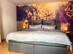 een slaapkamer met een bed met een schilderij aan de muur bij Winzerhof Männle in Oberkirch