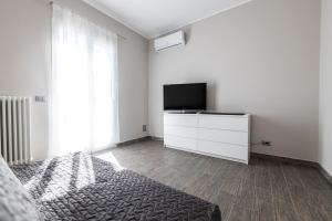 um quarto com uma cama e uma televisão de ecrã plano em Sanremo Dream - Casa Camilla em Sanremo