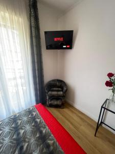 1 dormitorio con silla y TV en la pared en Trastevere Sweet Rest en Roma