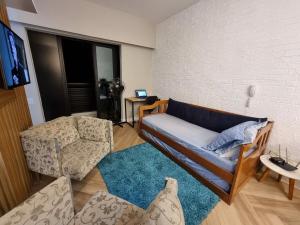 a living room with a couch and a chair at Conjunto Estudio e Duplex Selenita in Barueri