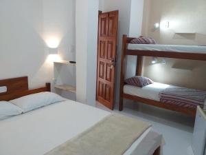 a bedroom with two bunk beds and a door at Hotel Pousada Hamburgo in Porto Seguro