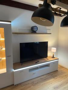 ein Wohnzimmer mit einem Flachbild-TV an einer weißen Wand in der Unterkunft Harztörchen in Halberstadt