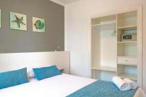 a bedroom with a white bed with blue pillows at Hyde Park Lane in Puerto del Carmen