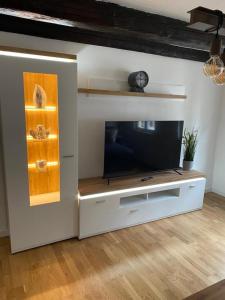 a living room with a tv in a white entertainment center at Harzromantik in Halberstadt