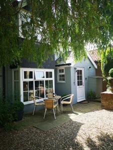 un patio con mesa y sillas frente a una casa en The Saddlery Holiday Cottage - Near Wolds And Coast, en North Thoresby