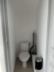 een badkamer met een toilet in een witte kamer bij Villa Magali - Appartement climatisé T3 Duplex - Grau-du-Roi - Hypercentre 20 m de la plage in Le Grau-du-Roi