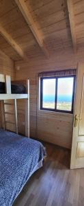 a bedroom with a bed and a window in a cabin at Las casitas de Pao in El Pinar del Hierro
