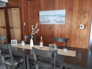 a table with chairs and a bottle of wine on it at Lake View Cottage on Lake Erie in Ashtabula