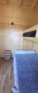 a bedroom with a bed in a wooden cabin at Las casitas de Pao in El Pinar del Hierro