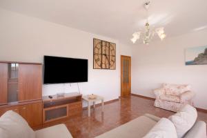 a living room with a tv and a couch and a chair at Casa del Pescador planta alta in Las Eras