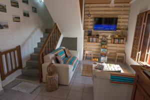 a living room with a staircase and a couch at Hostel Luz in Anchieta