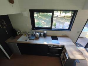 a small kitchen with a sink and a window at Tiny house chez Caroline in Gaillan-en-Médoc