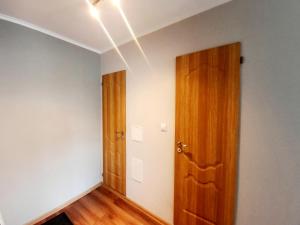 an empty room with a wooden door and white walls at Light Apartment in Rīga