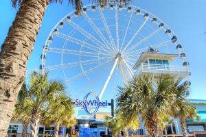 a ferris wheel in front of a mall with palm trees at Dry Dock 101 in Myrtle Beach