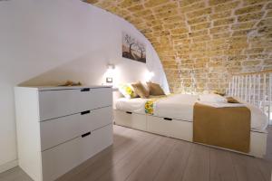ein Schlafzimmer mit einem Bett und einer Ziegelwand in der Unterkunft Dimora Don Mimì in Morciano di Leuca