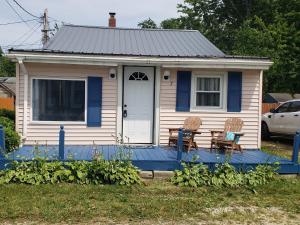 a small house with two chairs on a blue porch at Lake View Cottage on Lake Erie in Ashtabula