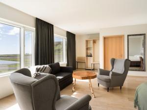 a living room with a couch and chairs and a bed at Hotel Katla by Keahotels in Vík